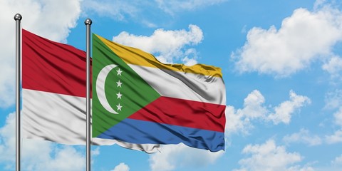 Monaco and Comoros flag waving in the wind against white cloudy blue sky together. Diplomacy concept, international relations.