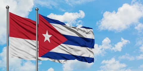Monaco and Cuba flag waving in the wind against white cloudy blue sky together. Diplomacy concept, international relations.