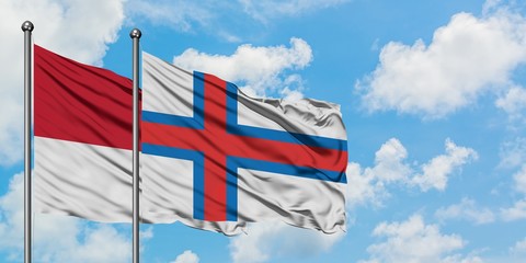 Monaco and Faroe Islands flag waving in the wind against white cloudy blue sky together. Diplomacy concept, international relations.