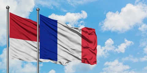 Monaco and France flag waving in the wind against white cloudy blue sky together. Diplomacy concept, international relations.