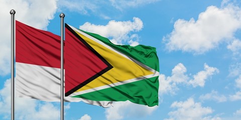 Monaco and Guyana flag waving in the wind against white cloudy blue sky together. Diplomacy concept, international relations.