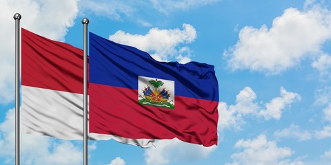 Monaco and Haiti flag waving in the wind against white cloudy blue sky together. Diplomacy concept, international relations.