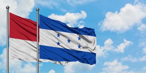 Monaco and Honduras flag waving in the wind against white cloudy blue sky together. Diplomacy concept, international relations.