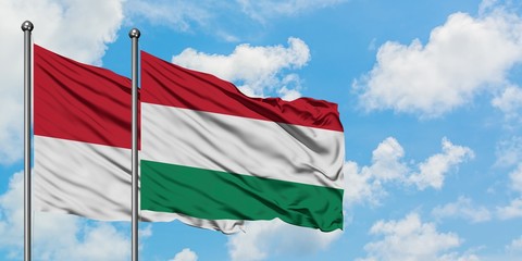 Monaco and Hungary flag waving in the wind against white cloudy blue sky together. Diplomacy concept, international relations.