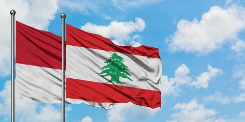 Monaco and Lebanon flag waving in the wind against white cloudy blue sky together. Diplomacy concept, international relations.
