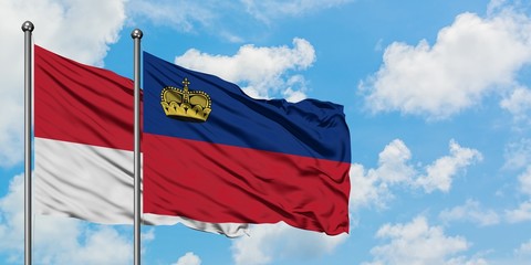 Monaco and Liechtenstein flag waving in the wind against white cloudy blue sky together. Diplomacy concept, international relations.