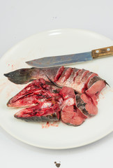Cut fresh fish fillet in a fish shop, chef cutting red fish on wooden plate in the kitchen.