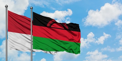 Monaco and Malawi flag waving in the wind against white cloudy blue sky together. Diplomacy concept, international relations.