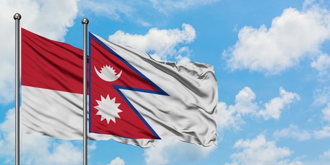 Monaco and Nepal flag waving in the wind against white cloudy blue sky together. Diplomacy concept, international relations.