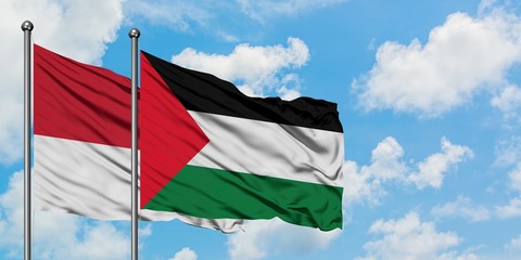 Monaco and Palestine flag waving in the wind against white cloudy blue sky together. Diplomacy...