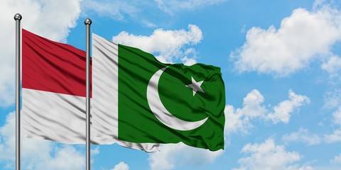 Monaco and Pakistan flag waving in the wind against white cloudy blue sky together. Diplomacy concept, international relations.