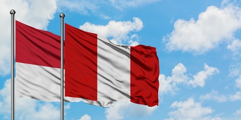 Monaco and Peru flag waving in the wind against white cloudy blue sky together. Diplomacy concept, international relations.