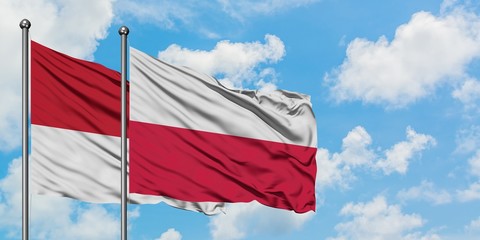 Monaco and Poland flag waving in the wind against white cloudy blue sky together. Diplomacy concept, international relations.