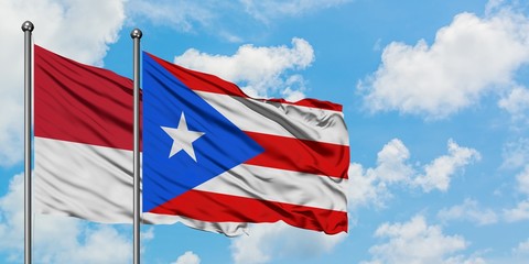 Monaco and Puerto Rico flag waving in the wind against white cloudy blue sky together. Diplomacy concept, international relations.