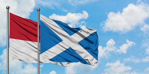 Monaco and Scotland flag waving in the wind against white cloudy blue sky together. Diplomacy concept, international relations.