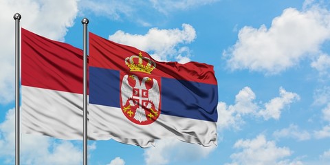 Monaco and Serbia flag waving in the wind against white cloudy blue sky together. Diplomacy concept, international relations.
