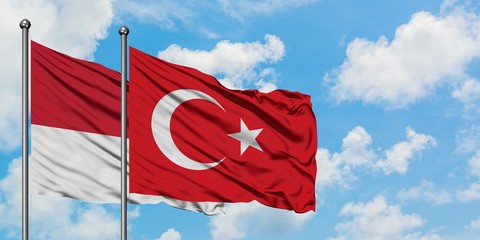 Monaco and Turkey flag waving in the wind against white cloudy blue sky together. Diplomacy concept, international relations.