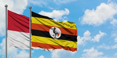 Monaco and Uganda flag waving in the wind against white cloudy blue sky together. Diplomacy concept, international relations.