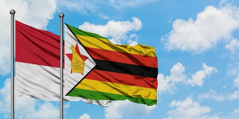 Monaco and Zimbabwe flag waving in the wind against white cloudy blue sky together. Diplomacy concept, international relations.