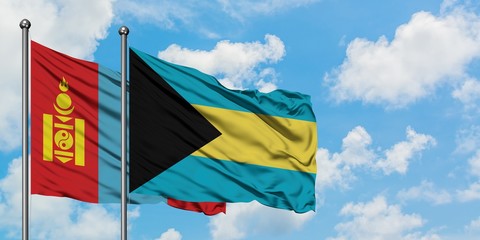 Mongolia and Bahamas flag waving in the wind against white cloudy blue sky together. Diplomacy concept, international relations.