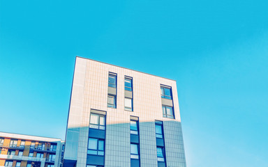Fragment in Modern residential apartment with flat building exterior. Detail of New luxury house and home complex. Part of City Real estate property and condo architecture. Copy space. Blue sky