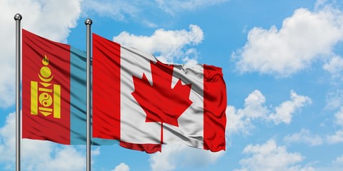 Mongolia and Canada flag waving in the wind against white cloudy blue sky together. Diplomacy concept, international relations.