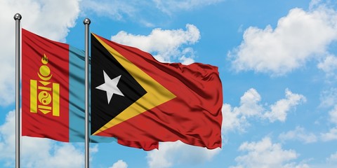 Mongolia and East Timor flag waving in the wind against white cloudy blue sky together. Diplomacy concept, international relations.