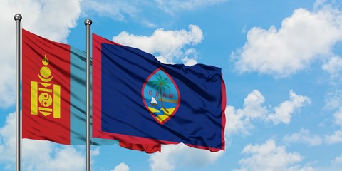 Mongolia and Guam flag waving in the wind against white cloudy blue sky together. Diplomacy concept, international relations.