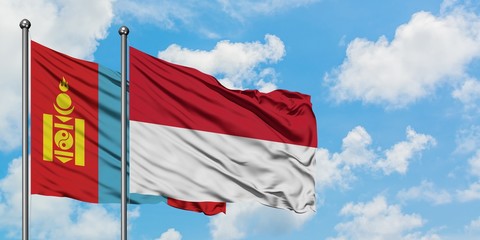 Mongolia and Indonesia flag waving in the wind against white cloudy blue sky together. Diplomacy concept, international relations.