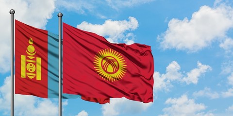 Mongolia and Kyrgyzstan flag waving in the wind against white cloudy blue sky together. Diplomacy...