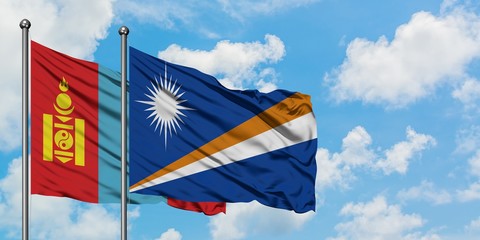 Mongolia and Marshall Islands flag waving in the wind against white cloudy blue sky together. Diplomacy concept, international relations.