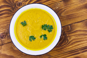Pumpkin soup on a wooden table. Top view