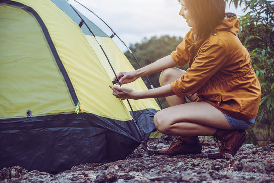 Traveller asian woman putting up a tent in nature,Enjoying camping concept