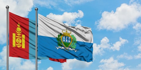 Mongolia and San Marino flag waving in the wind against white cloudy blue sky together. Diplomacy...