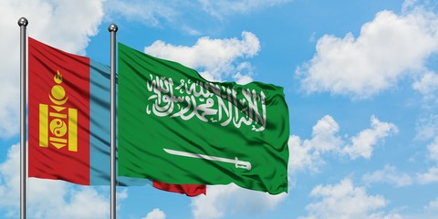 Mongolia and Saudi Arabia flag waving in the wind against white cloudy blue sky together. Diplomacy concept, international relations.