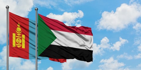Mongolia and Sudan flag waving in the wind against white cloudy blue sky together. Diplomacy concept, international relations.