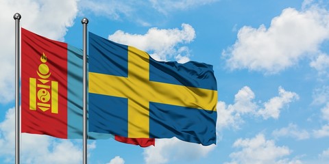 Mongolia and Sweden flag waving in the wind against white cloudy blue sky together. Diplomacy...