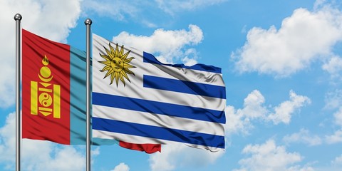 Mongolia and Uruguay flag waving in the wind against white cloudy blue sky together. Diplomacy concept, international relations.