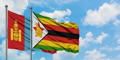 Mongolia and Zimbabwe flag waving in the wind against white cloudy blue sky together. Diplomacy concept, international relations.