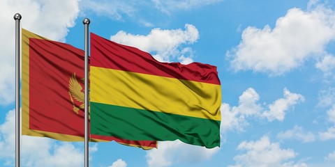 Montenegro and Bolivia flag waving in the wind against white cloudy blue sky together. Diplomacy concept, international relations.