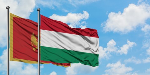Montenegro and Hungary flag waving in the wind against white cloudy blue sky together. Diplomacy concept, international relations.