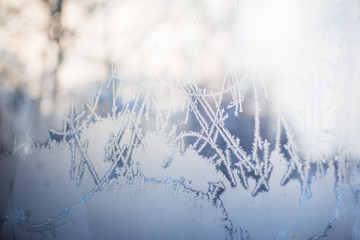 Frost patterns on the window. It's a frosty morning, the sun shining through the blue-and-white patterns on the glass