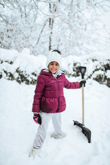 Portrait of a girl with a showel in the snow.