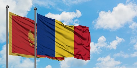 Montenegro and Romania flag waving in the wind against white cloudy blue sky together. Diplomacy concept, international relations.