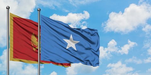 Montenegro and Somalia flag waving in the wind against white cloudy blue sky together. Diplomacy concept, international relations.
