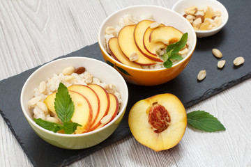 Sorghum salad with nuts and fresh peach on stone board.