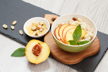 Sorghum salad with nuts and fresh peach on stone board.