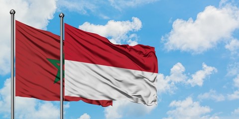 Morocco and Indonesia flag waving in the wind against white cloudy blue sky together. Diplomacy concept, international relations.