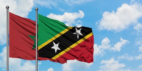 Morocco and Saint Kitts And Nevis flag waving in the wind against white cloudy blue sky together. Diplomacy concept, international relations.