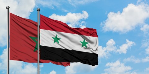 Morocco and Syria flag waving in the wind against white cloudy blue sky together. Diplomacy concept, international relations.